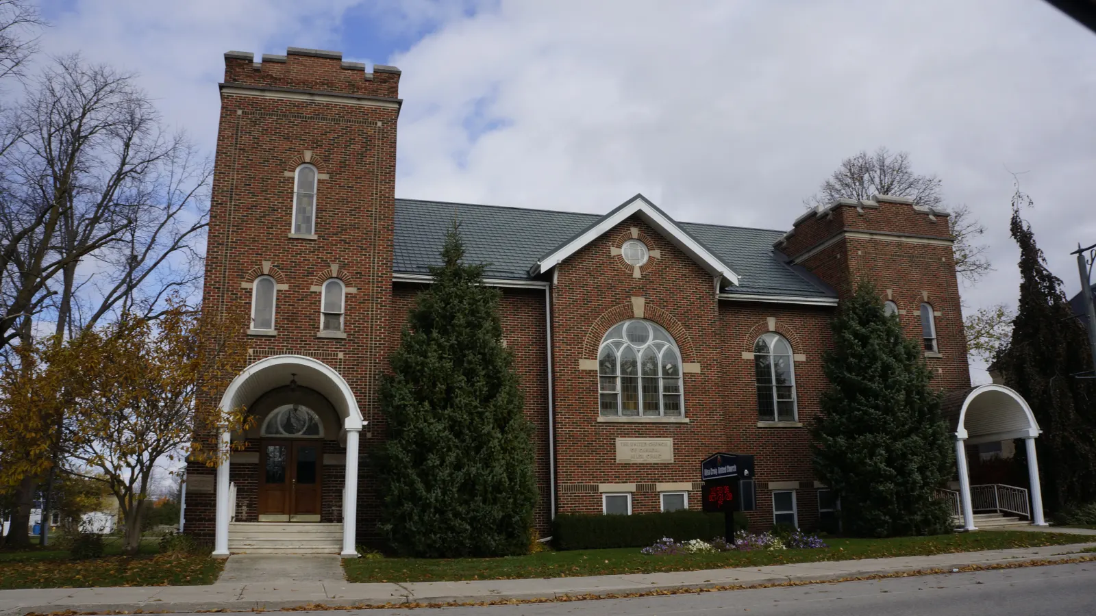 Ailsa Craig United Church, a red-brick church with a square tower, among autumn trees