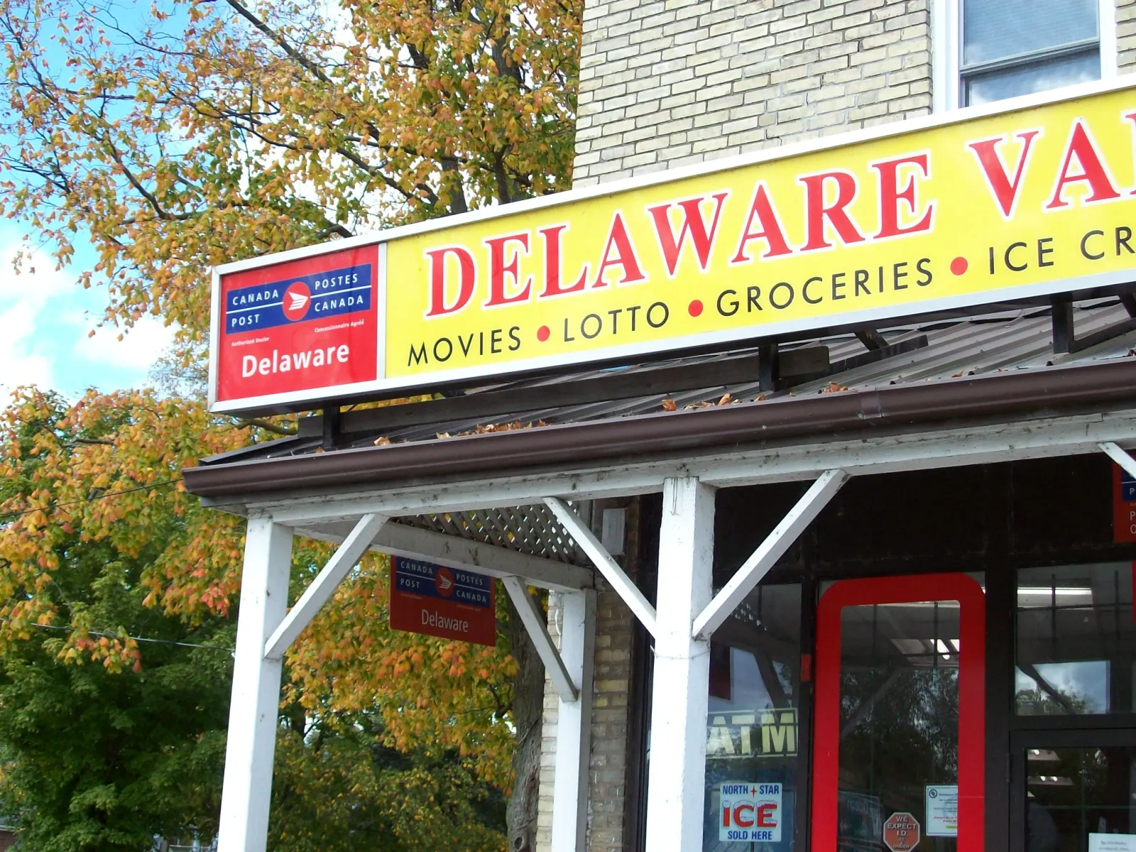 The Delaware post office and variety store sign under autumn leaves