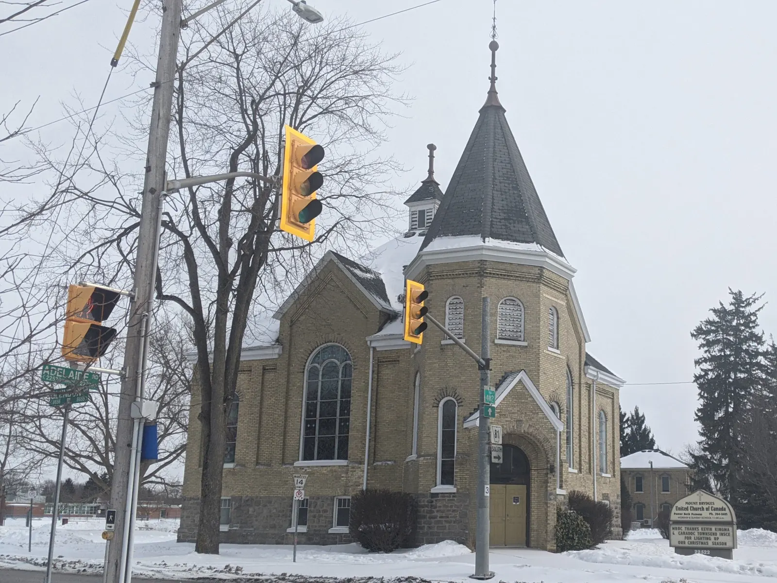 Mount Brydges United Church, a yellow-brick church with a round corner tower, at a village intersection