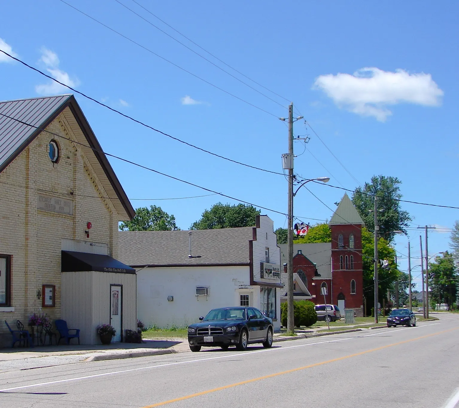 A street in Newbury on a sunny day, with an old yellow-brick hall and a red-brick church steeple