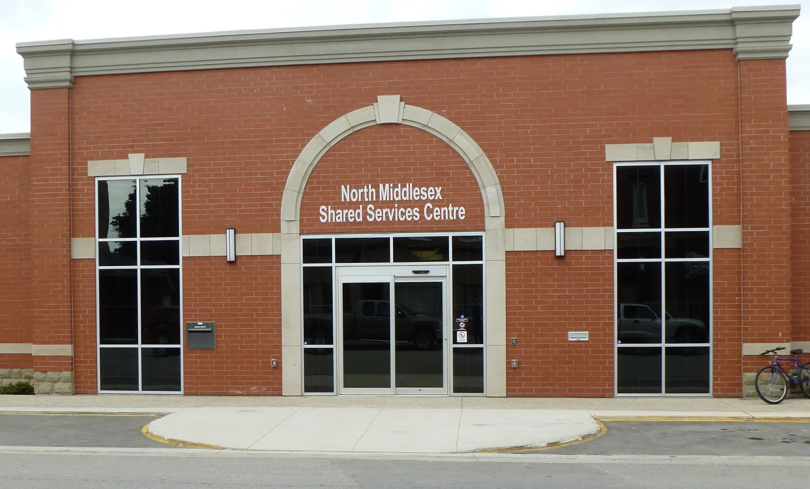 The North Middlesex Shared Services Centre, a red-brick building with an arched glass entrance