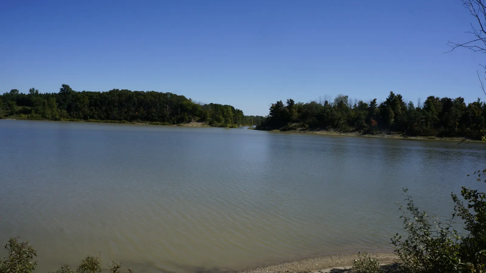 The Parkhill Dam reservoir on a clear day, ringed by trees