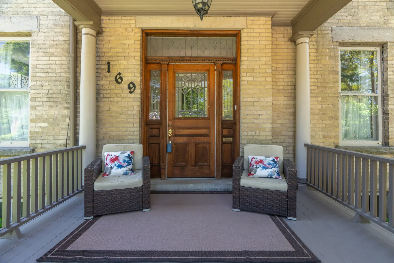 Wood front door with porch seating on either side