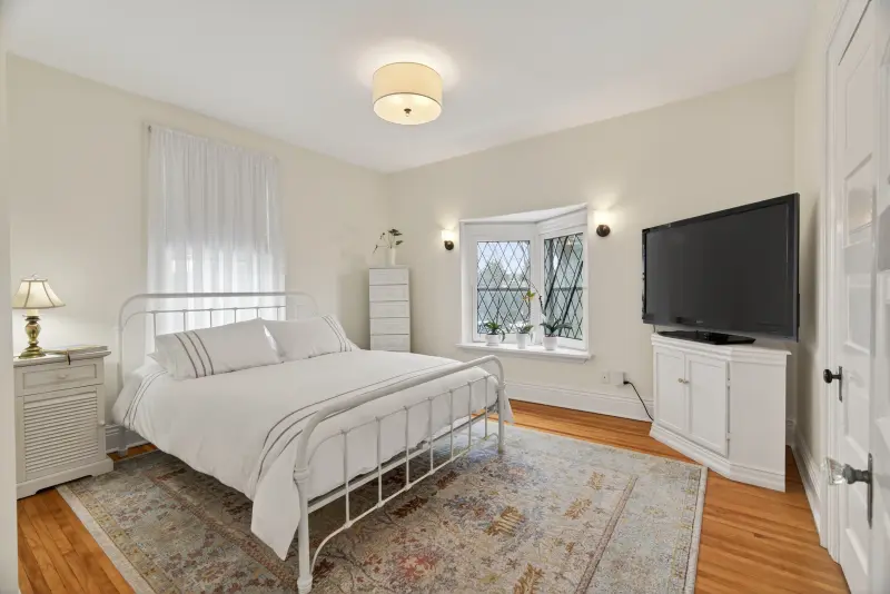 Bedroom with hardwood floors and a leaded-glass window