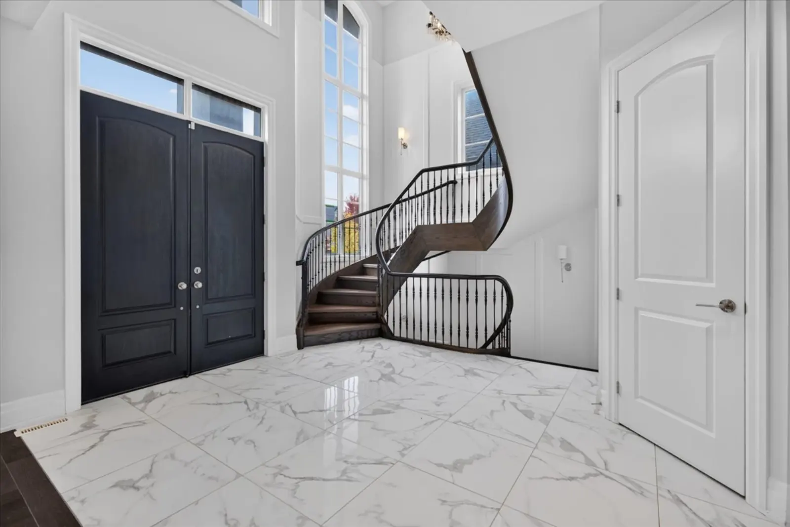 Front entry with a curved staircase and marble floor