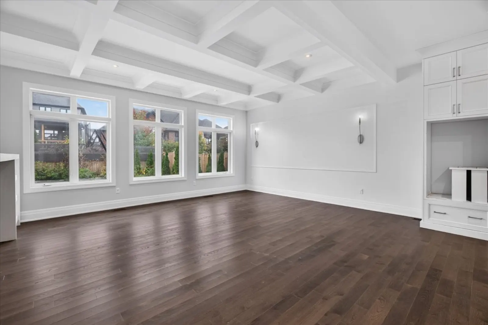 Great room with a coffered ceiling and a wall of windows