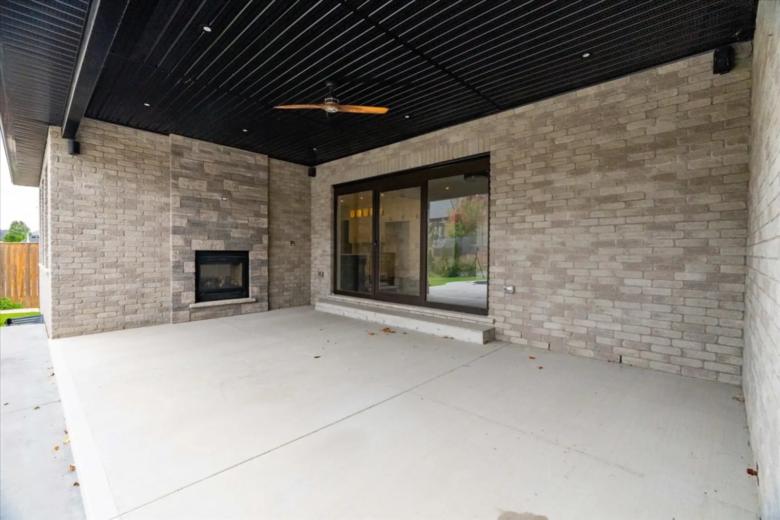 Covered back porch with the outdoor side of the fireplace