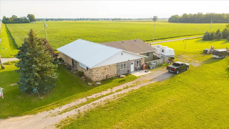 The building and its corner lot from the air, with fields behind