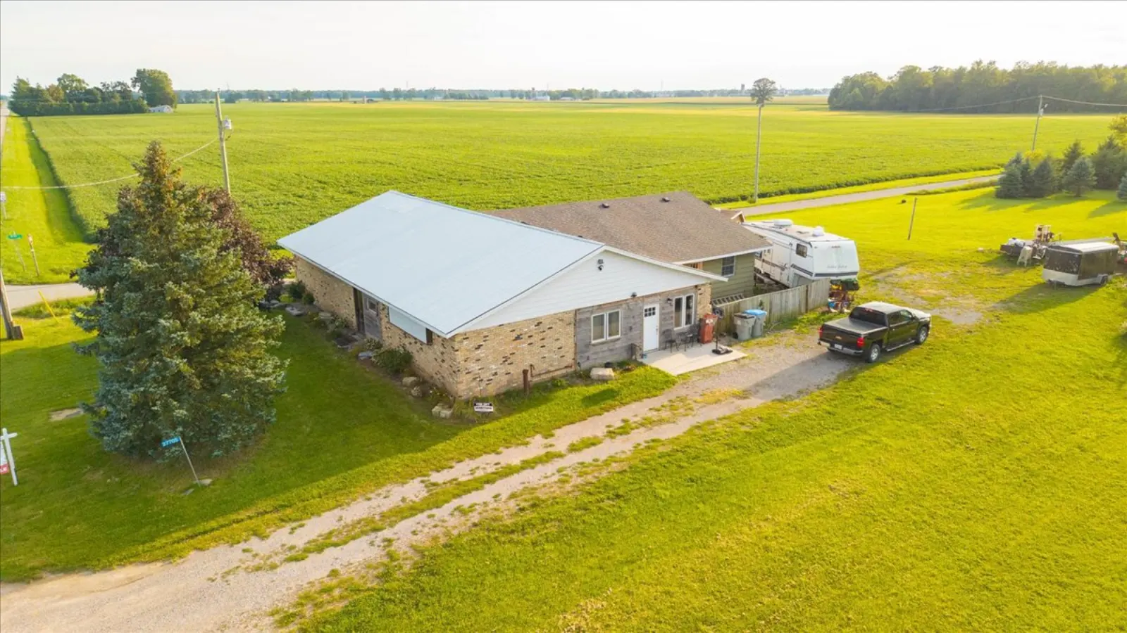 The building and its corner lot from the air, with fields behind
