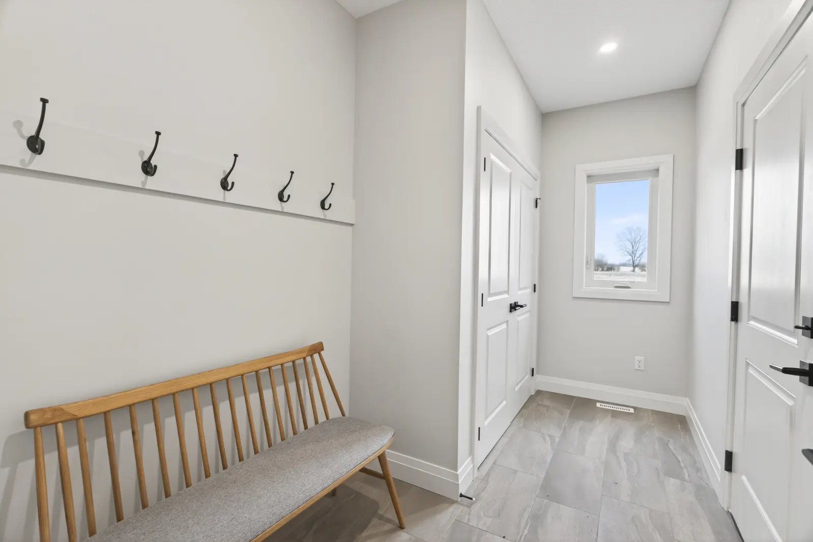 Model home: mudroom with a bench and wall hooks