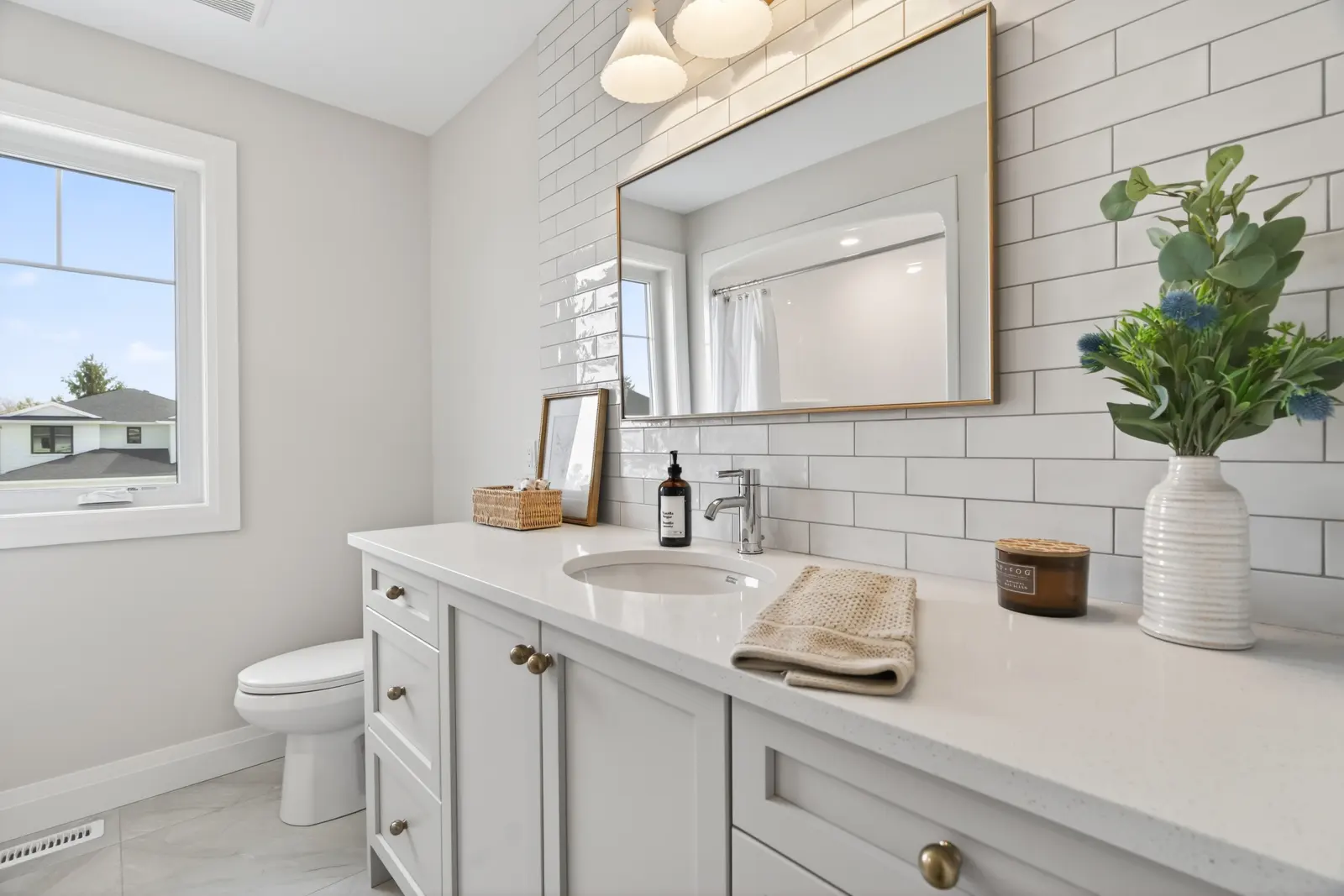 Model home: bathroom with a vanity and subway tile