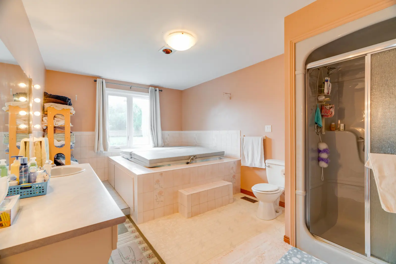 Bathroom with a jetted tub and a glass shower