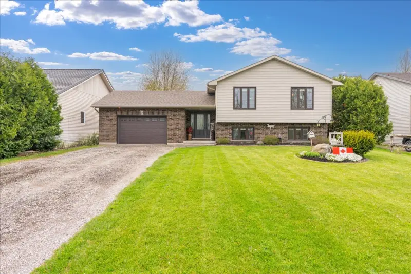 Front of the raised bungalow with a brick front and attached garage