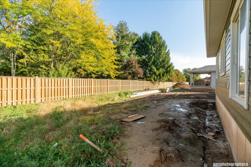 Back yard with a wood fence and trees beyond