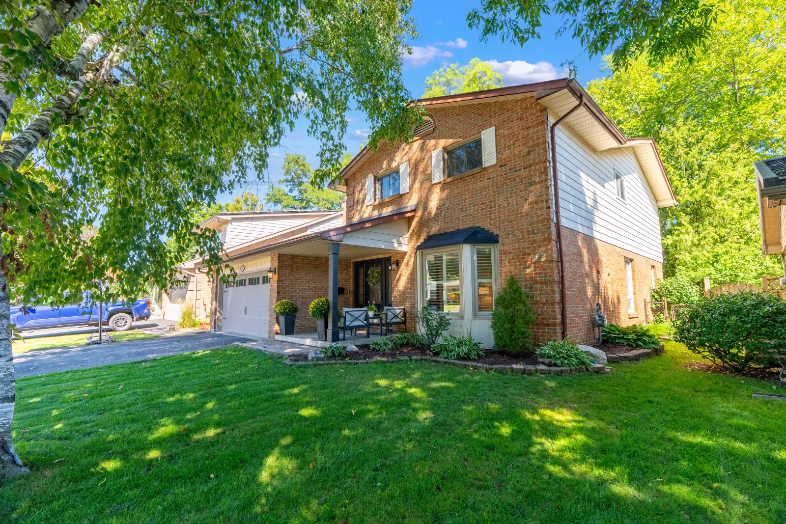 Front of the home: brick two-storey with a bay window and a covered porch