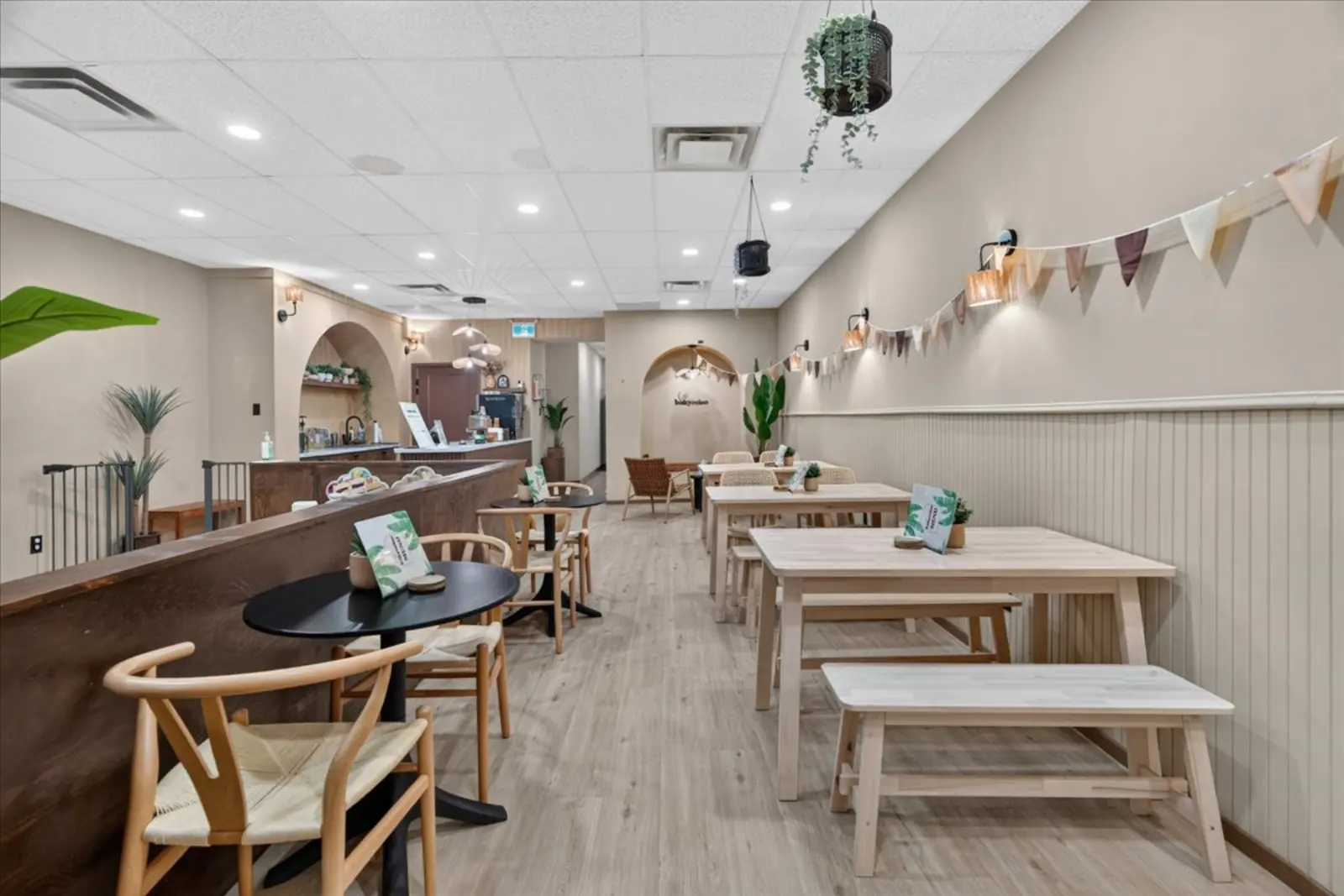 Café seating with wooden tables and chairs under string bunting