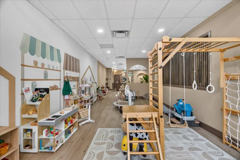 Play area with a wooden climbing frame and soft play pieces