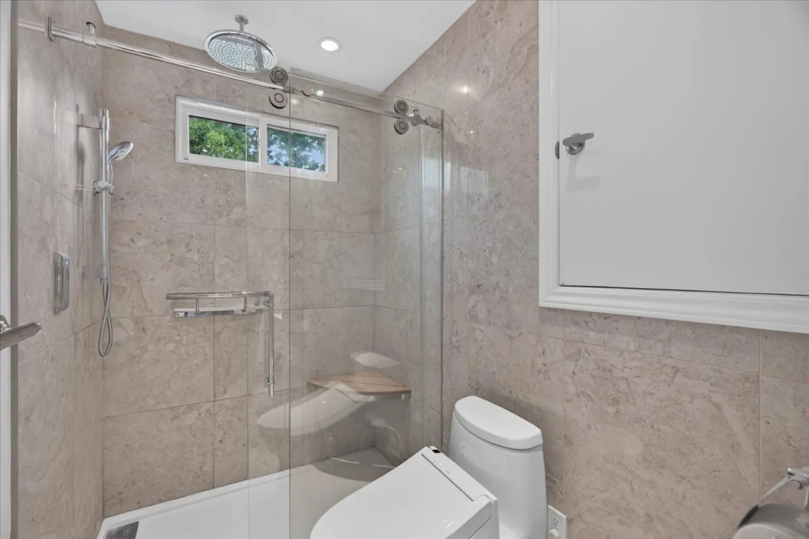 Tiled walk-in shower with a rain head and glass door