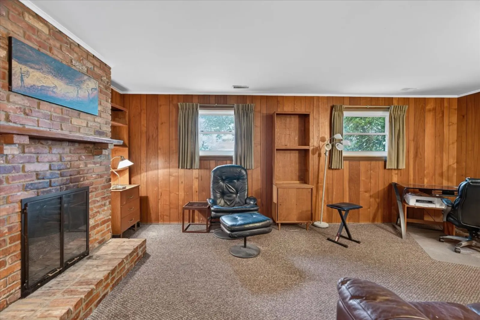 Rec room with a brick fireplace and wood panelling