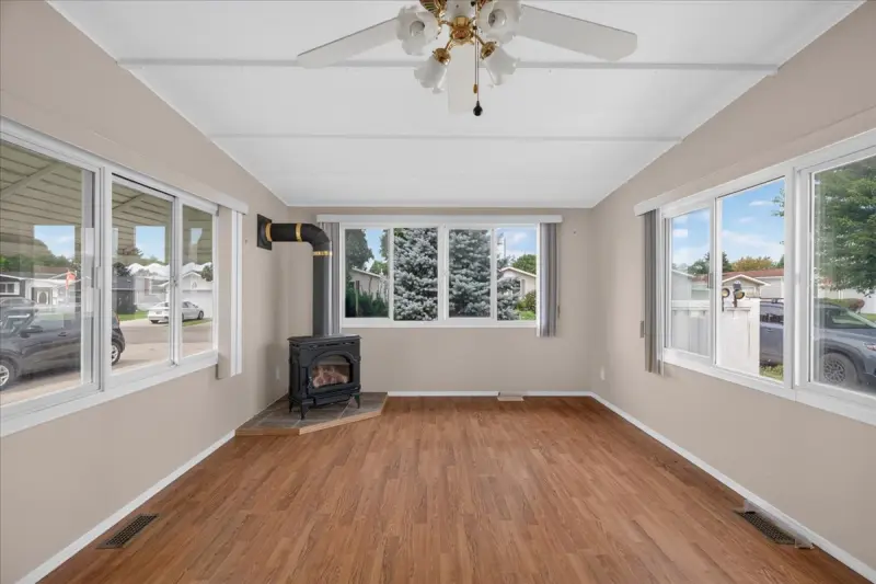 Living room with windows on three sides and a gas fireplace
